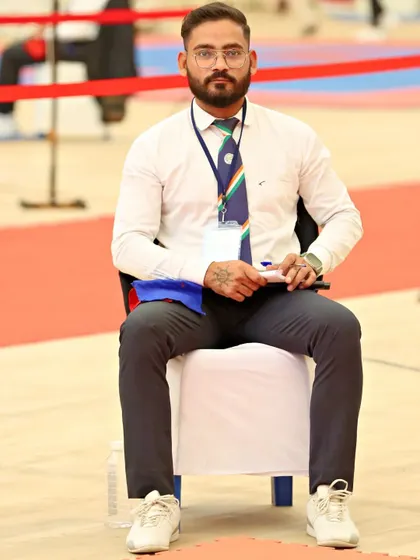 Seated as an official during a championship event. My role as an umpire requires sharp focus and a deep understanding of Taekwondo rules and techniques.