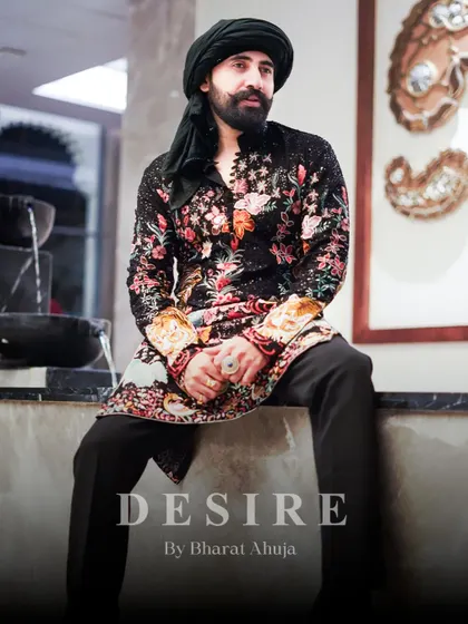 Seated in confidence, wearing a masterpiece. This full-length view shows how my floral and tiger embroidered kurta creates a complete, powerful silhouette. It is designed to make an impact from every angle.