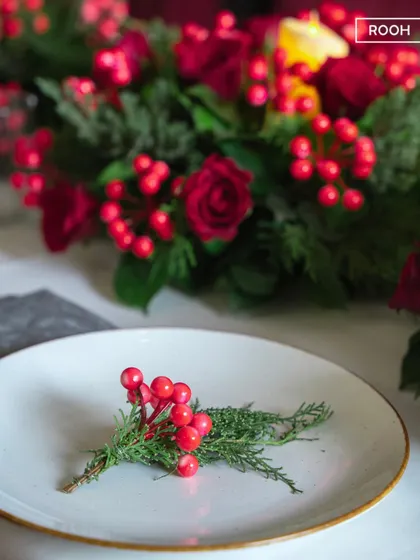 Taste the magic of Christmas with this simple, elegant detail. A sprig of holly on a plate is a small touch that signals the start of a festive meal.