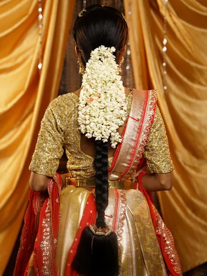 A full and fragrant bridal braid created using jasmine flowers stitched down its length. This style not only looks beautiful but also adds a traditional fragrance, perfect for a South Indian bride.