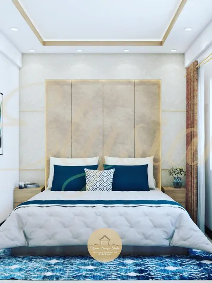 A luxurious master bedroom design for a project at Sai Lexus Serenity, Bangalore. The room features a floor-to-ceiling upholstered headboard with brass inlay details, a textured wallpaper, and a sophisticated color palette of beige and blue.