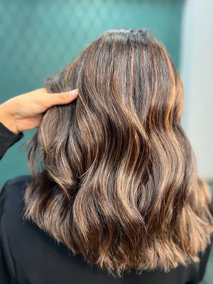 A detailed shot of the autumn-inspired hair color, showing the rich tones and healthy shine of the hair.
