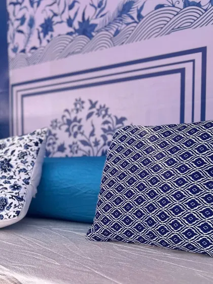Detail of the custom-printed cushions and backdrops, featuring blue and white patterns that evoke a Mediterranean or Jaipur-blue pottery feel.