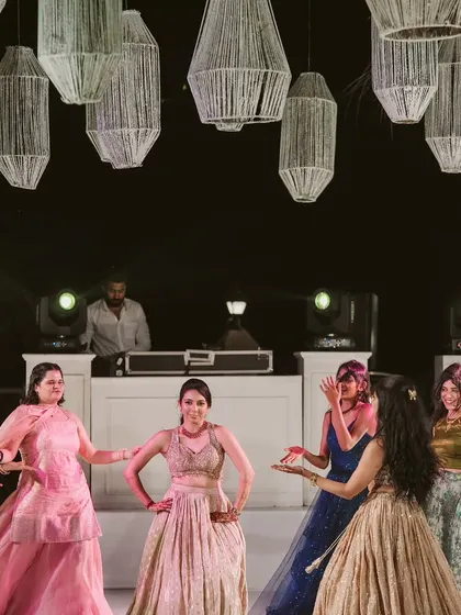The energy of a Sangeet night captured perfectly. The dance floor is illuminated by hanging lanterns, creating a festive atmosphere for all the performances.
