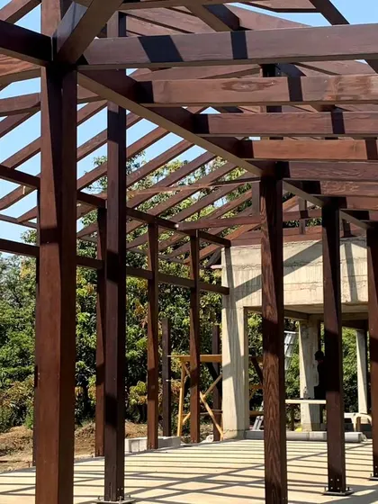 The exposed timber frame of a house under construction in Awas, Alibaug. This structure, with its rhythmic columns and beams, is designed to be a modern interpretation of traditional post-and-beam construction.