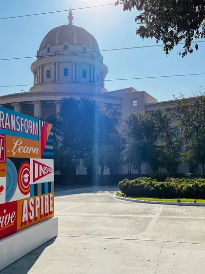 A view of the typographic canvas in its campus setting, with the university's main building in the background. The art is designed to integrate with and enhance the architectural environment.