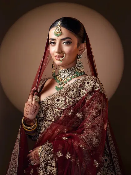 A confident and poised shot capturing the full bridal look against a clean studio background, allowing the outfit and styling to command attention.