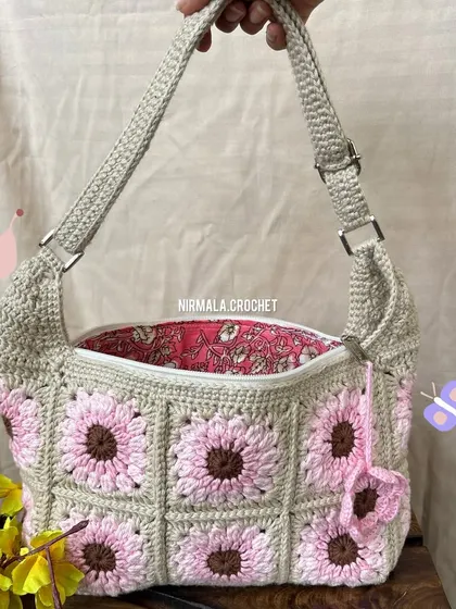 A closer look at the Blossom Meadow bag, featuring an adjustable strap, a zipper closure, and a cute flower charm.