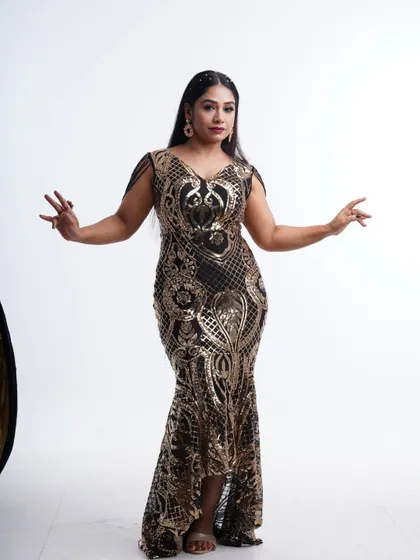 A full-length shot of a stunning black and gold sequin mermaid gown. This dress is designed to turn heads and is a favorite for glamour shoots.