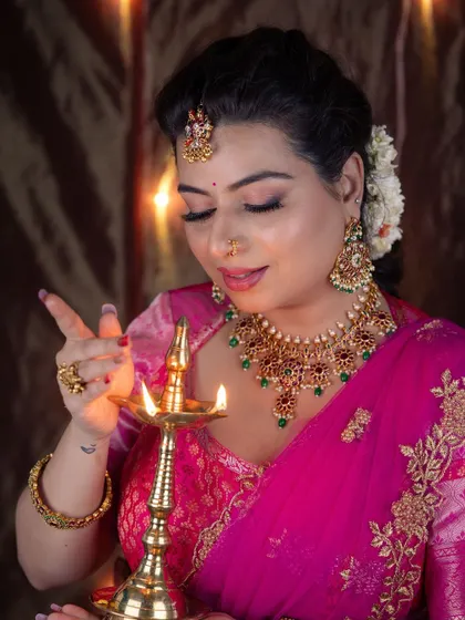 Another angle of the festive makeup, highlighting the shimmer on the eyes and the soft glow on the cheeks as she lights the diya.