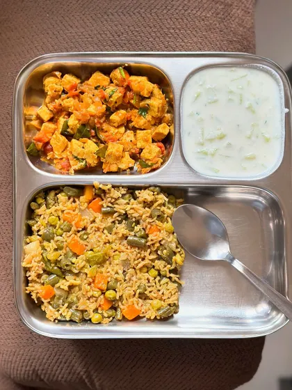 A gluten-free and vegetarian meal of vegetable pulav, paneer bhurji, and cucumber raita. It's flavorful, satisfying, and easy on the gut.