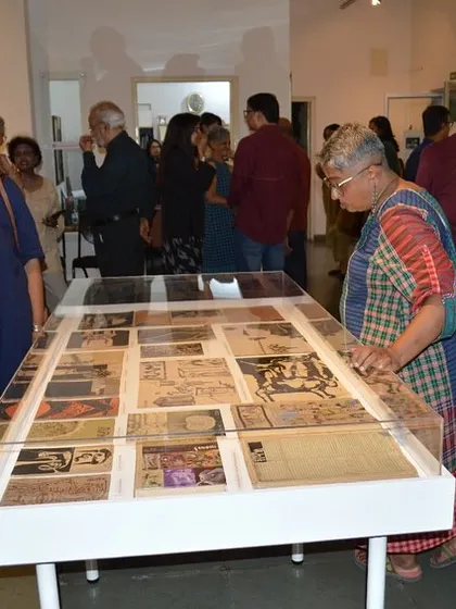 A visitor examining the archival vitrine at the 'Hand Prints' show.