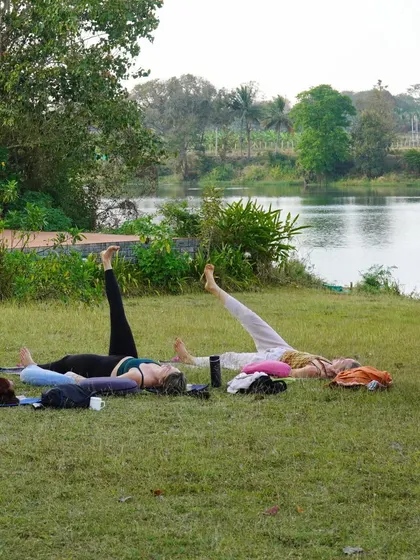 Another teaching practice session on the lawn. Students learn to guide others through asanas and relaxation, an essential part of becoming a yoga teacher.