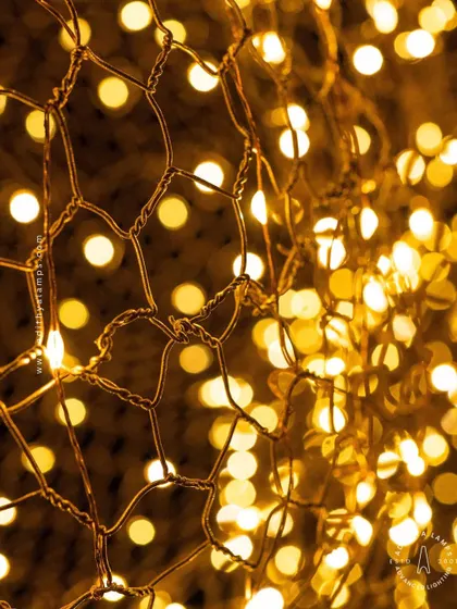We call this piece the 'Clouds of Abundance'. Formed from a delicate honeycomb mesh of gold wire embedded with tiny LED lights, these fixtures float like luminous clouds, casting a warm and magical glow.