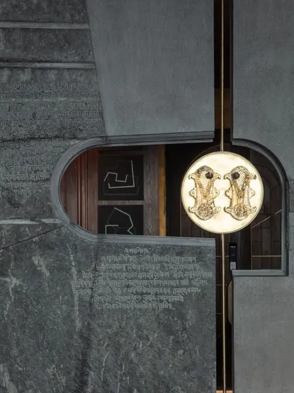 The water feature seen through a different lens, highlighting the etched Pali script on the stone and the circular light element. This view shows how we compose elements to create layered and meaningful vignettes.