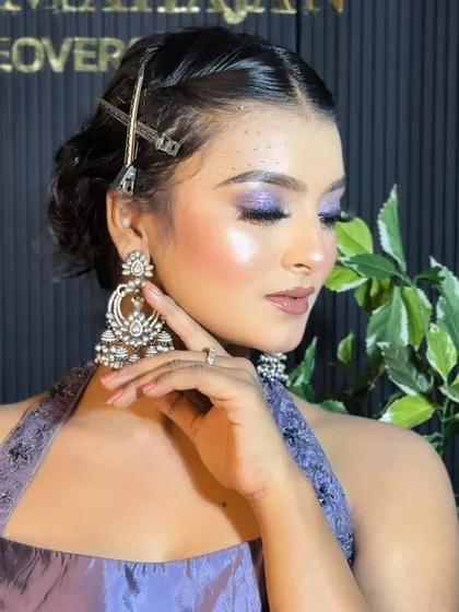 A close-up of the model's face, highlighting the intricate details of her eye makeup and jewelry.