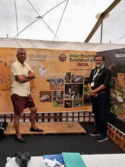 Our team standing proudly in front of the Uttar Pradesh Ecotourism display at the Global Birdfair. We partner with state tourism boards to promote responsible wildlife travel.