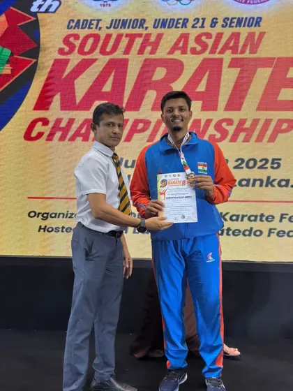 Jitendra Kumar receiving his gold medal from an official at the South Asian Karate Championship. This formal recognition is a crucial part of a professional athlete's career.