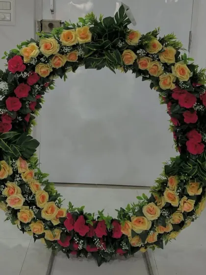 Another view of this classic red and yellow rose wreath, a versatile piece that brings color and elegance to any event.