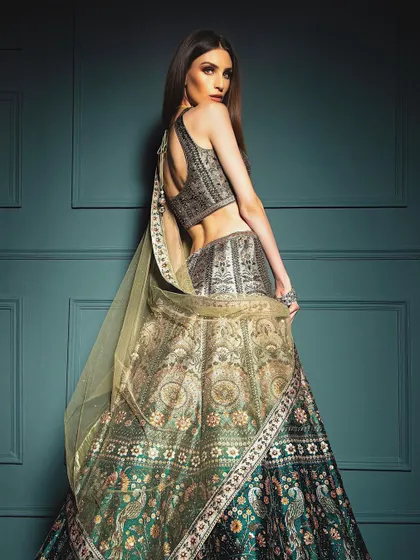 A full-length shot from the back, showcasing the intricate design of the lehenga skirt and the elegant drape of the dupatta. This angle is essential for showing the complete design of a garment.