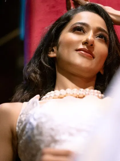 A candid, behind-the-scenes style shot of Radhika Narayan during her makeup touch-up. These moments often result in the most natural and beautiful portraits.