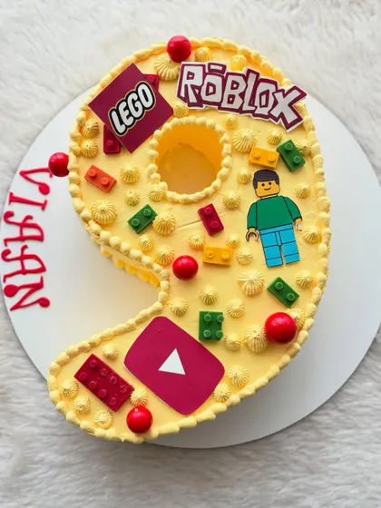 For a 9th birthday, I combined three favorites: Lego, Roblox, and YouTube. This number-shaped cake is decorated with edible bricks and logos for a fun, modern theme.