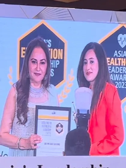 A candid moment on stage receiving the healthcare excellence award. It is an honor to be recognized for my contributions to the field of dermatology.