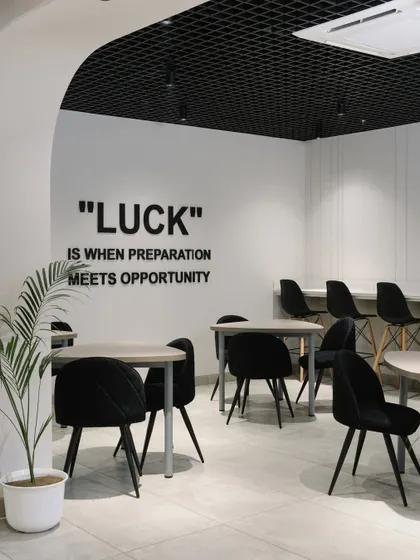 The staff cafeteria features a monochromatic black and white theme, with an inspirational quote on the wall. This space is designed for relaxation and social interaction.