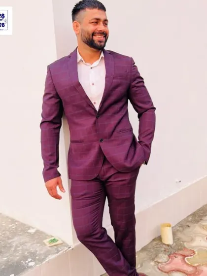 A happy client looking dapper in a custom-tailored burgundy plaid two-piece suit. The perfect fit makes all the difference for a sharp, formal look.