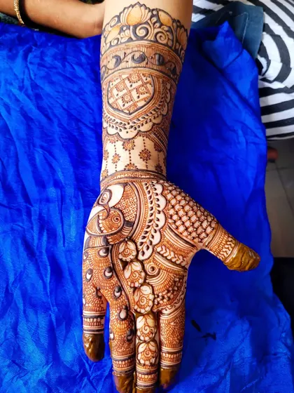 A sweet and simple floral henna piece. This design features a peacock on the palm and a heart motif on the wrist, making it a lovely choice for an engagement or party.