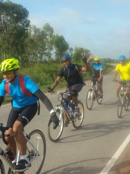 Action shot of the group cycling together, with riders smiling and enjoying the journey.