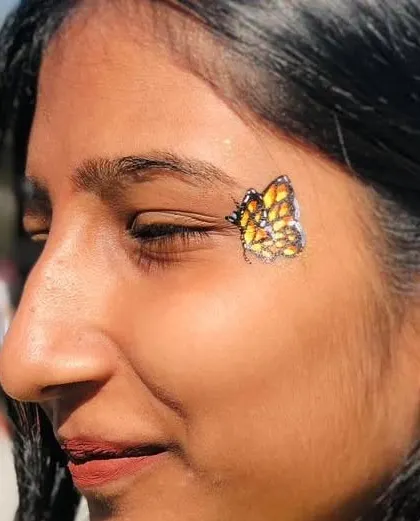 A beautiful monarch-style butterfly, painted with shades of orange and yellow and a touch of glitter.