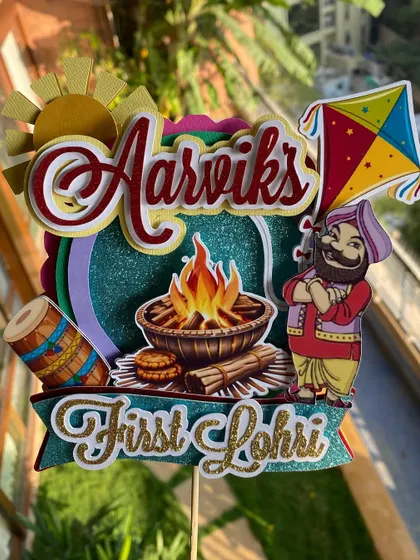 Another angle of the custom Lohri cake topper, showing the careful layering of the name and festive icons. It's a perfect keepsake for a special milestone.