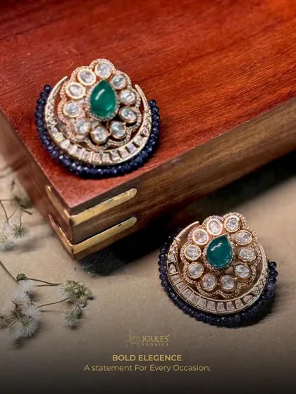 Festivities start with the tiniest sparkle. These bold studs feature a central emerald surrounded by polki diamonds and a navy blue beaded edge.