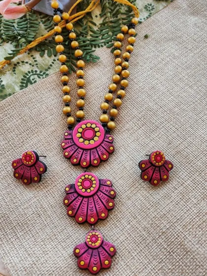 A three-layered floral pendant necklace in shades of onion pink and red. This design is perfect for creating a cascading floral look and is popular for festive wear.