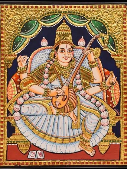 An unframed view of the Saraswati Tanjore painting. This allows a closer look at the intricate details of her veena, the delicate expression on her face, and the shimmering gold foil that adorns her.