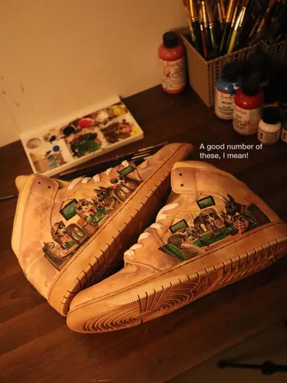 This is a detailed shot of the "Dogs Playing Poker" design on the coffee-dyed Air Jordan 1s. You can see the rich, layered colors and the aged effect the coffee provides to the entire sneaker.