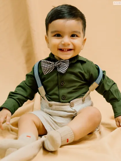 Dressed to impress! This little gentleman's smile is as charming as his bow tie and suspenders.