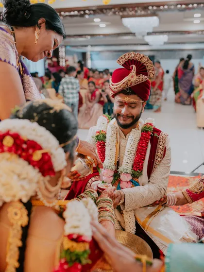 A candid moment during a traditional wedding ceremony, capturing the groom's smile.
