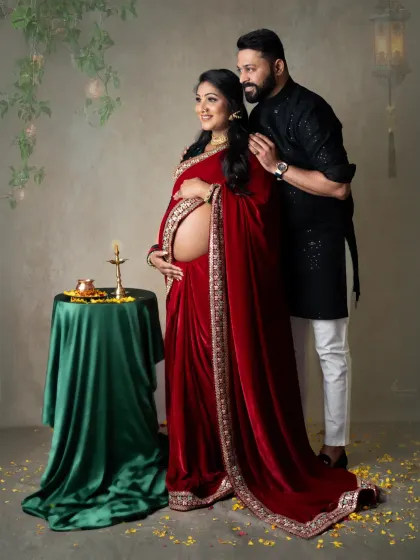 A powerful and loving portrait. The couple stands together, with the mom-to-be revealing her baby bump, a beautiful blend of tradition and modern confidence.