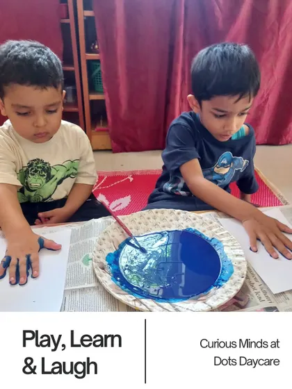 Two boys are deeply focused on a finger-painting activity. This sensory play is wonderful for creative expression and developing fine motor control in a fun, tactile way.