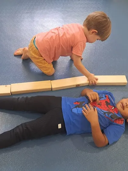 This student is focused on lining up the blocks perfectly to measure his friend's height. This play-based math activity makes learning concepts like length intuitive.