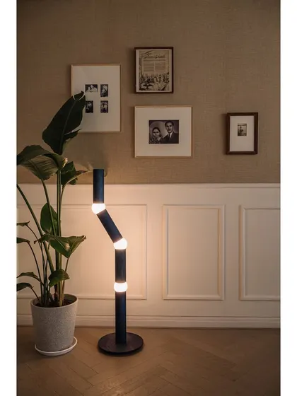 The den in Kanso House is a multi-functional space that serves as a sitting room, guest room, or prayer room. The walls are sheathed in jute wallpaper and adorned with the clients' personal black and white photographs, creating a gallery of memories.
