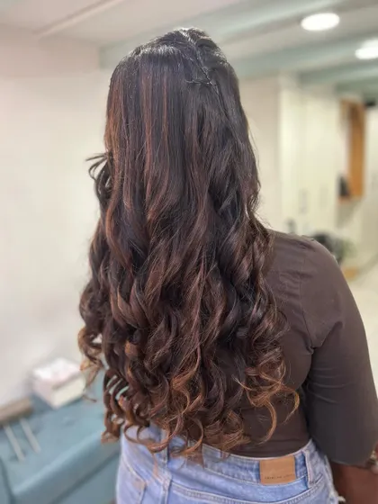 A slightly different angle of this curly style, showing a small braid detail that adds a touch of uniqueness to the look.