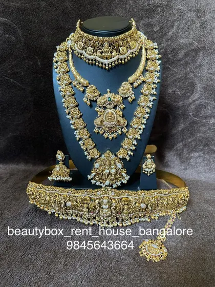 A complete and intricate temple jewellery set with pearl detailing. This rental includes a choker, multi-layered haaram, and a grand vaddanam.