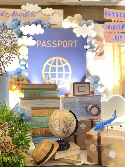 A close-up of the passport photo booth, complete with stacked travel books, a globe, and an old-fashioned camera prop.