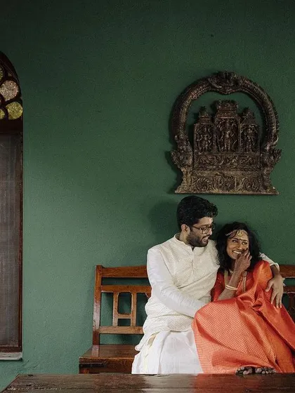 A quiet, intimate moment shared by the couple on a wooden bench. The traditional architecture and soft lighting create a serene and romantic atmosphere for this beautiful portrait.