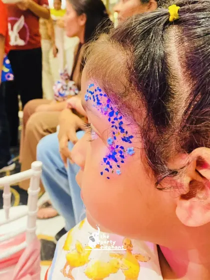 Another example of the beautiful and intricate glitter face art our team provides, adding a touch of sparkle to every child's day.