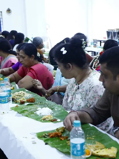 A side view of guests enjoying the variety of dishes served on their banana leaves.