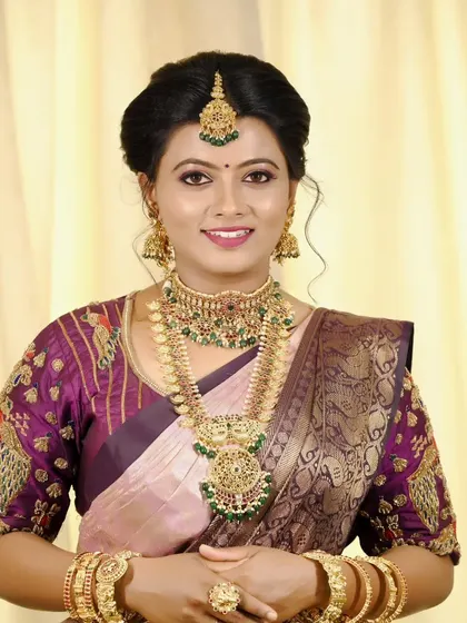 A full-frontal bridal portrait, showing the complete traditional look with a beautiful saree, jewelry, and elegant hair updo.